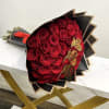 Bouquet of red roses wrapped in black paper with gold butterfly accents