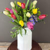 Colorful tulip bouquet in a white metal vase