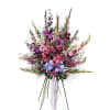 An elegant standing floral arrangement featuring a vibrant blend of purple, lavender