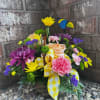 Basket arrangement of colorful flowers with a yellow ribbon and butterfly pick