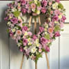 A soft and graceful heart-shaped arrangement designed with delicate blush and ivory
