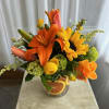 Orange and yellow floral arrangement in a clear glass vase