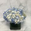 Blue and white hydrangea bouquet in a dark glass vase