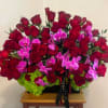 A lush cascade of deep red roses and bright pink orchids set