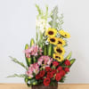Tall mixed flower arrangement with red roses, pink alstroemeria, and sunflowers