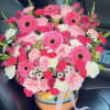 Bright pink gerbera daisies take center stage in this joyful flower arrangement