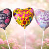 Three heart-shaped foil balloons in playful pink, purple, yellow and white make