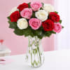 Bouquet of red, pink, and white roses in a clear glass vase