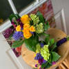 Two colorful hand-tied bouquets with yellow roses and purple flowers