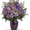 Lavender roses and purple flowers in a purple glass vase