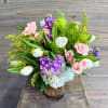 A beautiful arrangement of soft spring blooms in a specialty glass vase.