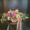 Pastel floral arrangement in a pink hat box with ribbon
