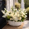 White floral arrangement in a white wicker basket