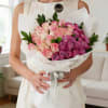 A stunning and elegant bouquet featuring 50 purple and pink roses, beautifully