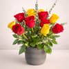 A compact cluster of red and yellow roses arranged upright in a