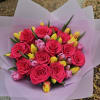 Bouquet of hot pink roses and yellow tulips wrapped in pale pink paper