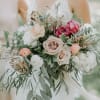 A romantic garden-style bridal bouquet featuring soft blush roses, rich burgundy accents