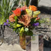 Mixed bouquet in a vase with a box of chocolates beside it
