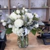 A lush mix of roses, spray roses, hydrangea, lisianthus, dusty miller and