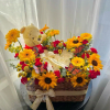 Basket arrangement of sunflowers, red flowers, and a teddy bear