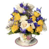 A sunny cluster of yellow and white roses nests in a decorative