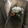 White rose boutonniere on a brown suit jacket