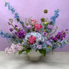 A lush, flowing arrangement of cool-toned blooms designed to feel peaceful and
