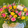 Basket arrangement of pink and yellow roses with mixed flowers