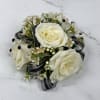 Cream-white roses contrasted with black and silver shimmering ribbon make this wrist