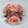 A cluster of blush pink roses accented with tiny pink filler blooms