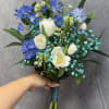 White tulips with blue delphinium-like blooms and teal aqua filler, hand-tied with