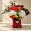 A refined and elegant floral arrangement featuring vibrant orange and red roses
