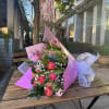 An elegant bouquet featuring 12 tulips, baby's breath, and greenery, wrapped in