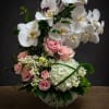 High style arrangement with two stem orchid, roses, hydrangea in ceramic container.