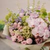 Bouquet of pale pink orchids, roses, and green hydrangeas