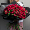 Large bouquet of deep red roses wrapped in black paper