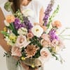 Mixed bouquet in a brass bowl with peach, white, and purple flowers
