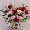  This delicate floral arrangement, presented in a hand-painted ceramic vase, is