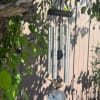 Silver wind chime hanging among tree branches