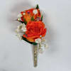 Two vivid orange rose blooms make this boutonniere a bright, celebratory accent