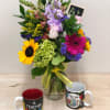 Mixed bouquet in a glass vase with two teacher-themed mugs in front