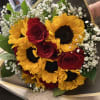 Bright sunflower faces ring the outside of this hand-tied flower arrangement, making