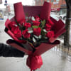 Bouquet of red roses wrapped in burgundy paper