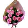 Bouquet of pink roses wrapped in brown and pink paper with a pink ribbon tie