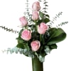 Pink roses arranged in a tall glass vase with eucalyptus foliage