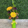 Yellow gerbera daisies in a green vase with purple accents
