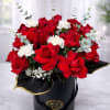 Red roses and white carnations arranged in a black hatbox