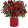 Red roses and pink flowers in a red vase