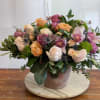 Mixed bouquet of roses and orchids in a ceramic vase