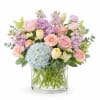 Featuring light blue hydrangea, blush roses, peach carnations, pale yellow tulips, lavender